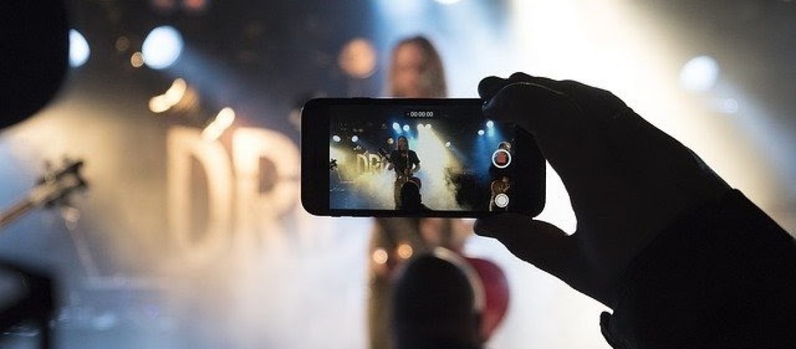Person at live concert recording it on their phone